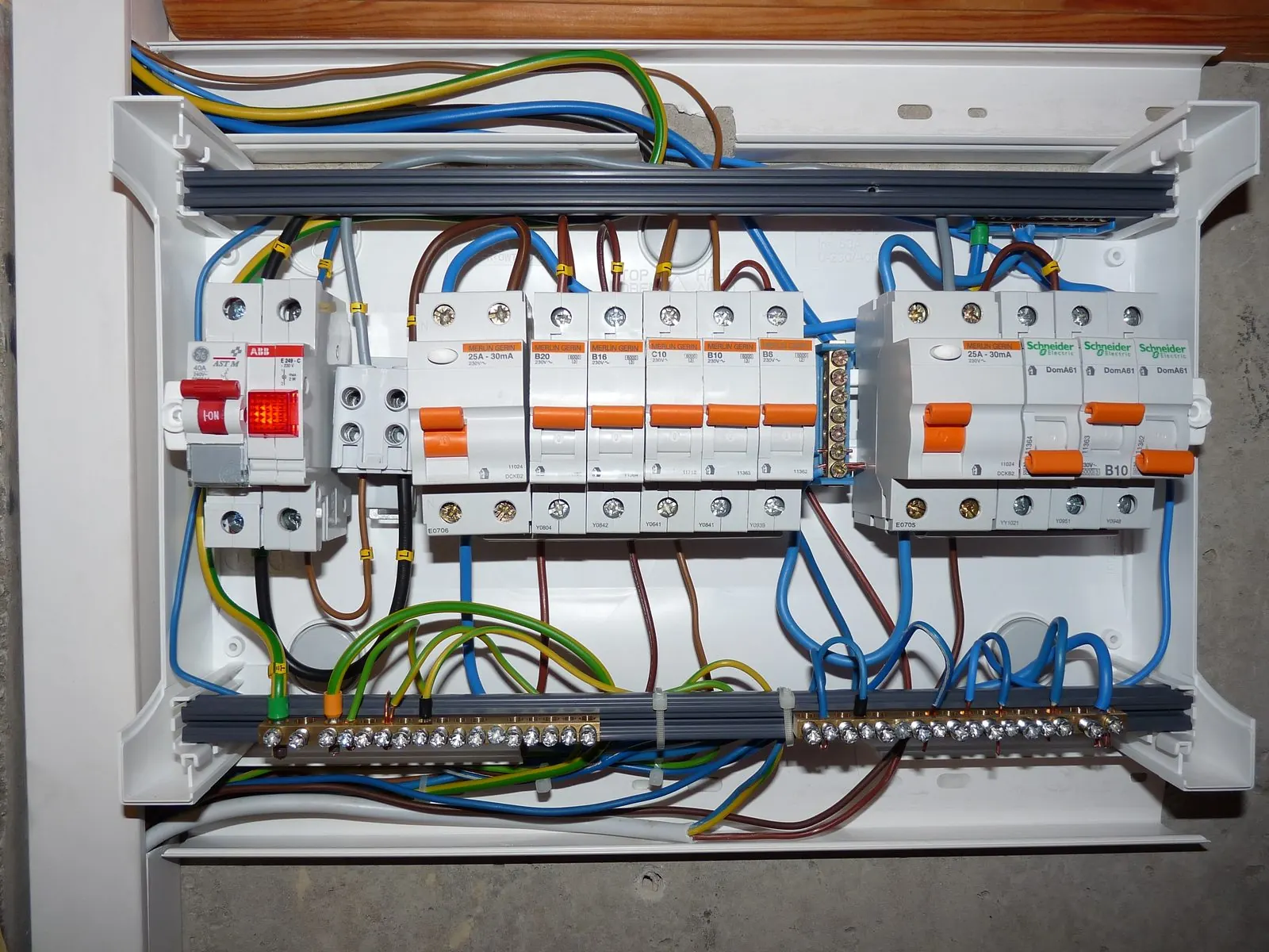 Cuadro eléctrico sin tapa con diferenciales, automáticos y cables de colores conectados al carril DIN